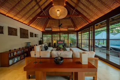 a living room with a couch and a table at Villa Ramadewa Beachside with Authentic Charm in Seminyak