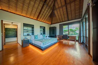 a bedroom with a bed and a desk in it at Villa Ramadewa Beachside with Authentic Charm in Seminyak