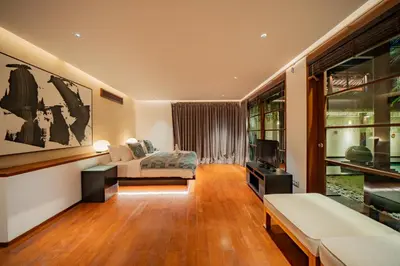 a living room with a bed and a television at Villa Ramadewa Beachside with Authentic Charm in Seminyak