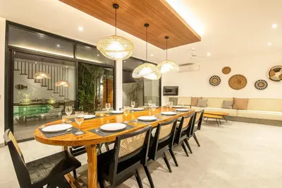 a dining room with a large wooden table and chairs at Tropical 5BR Modern Haven 400m from Canggu in Canggu