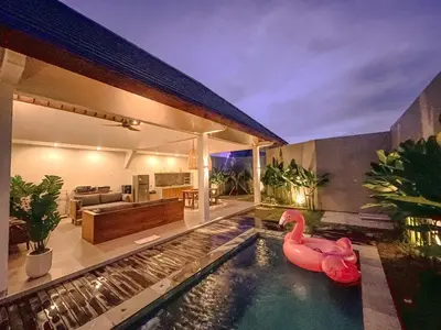 a swimming pool with two pink flamingos in a house at Villa Sinergi Seminyak 7 in Seminyak