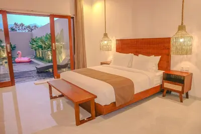 a bedroom with a bed and a table and a window at Villa Sinergi Seminyak 7 in Seminyak