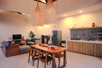a kitchen and a living room with a wooden table at Villa Sinergi Seminyak 7 in Seminyak