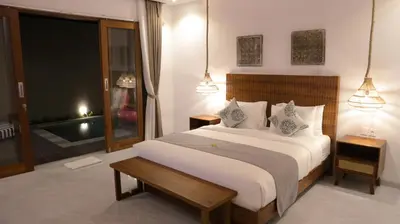 a bedroom with a large white bed with two lamps at Villa Sinergi Seminyak 8 in Seminyak
