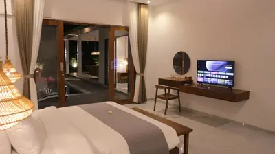 a bedroom with a bed and a television in it at Villa Sinergi Seminyak 8 in Seminyak