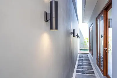 a hallway with a light fixture on the wall at Villa Baile Bali by Great Bali Villas in Jimbaran