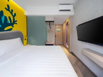 a bedroom with a bed and a flat screen tv at Quest Vibe Dewi Sri Bali in Legian