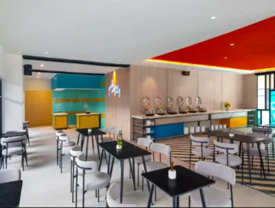 a restaurant with tables and chairs and a counter at Quest Vibe Dewi Sri Bali in Legian