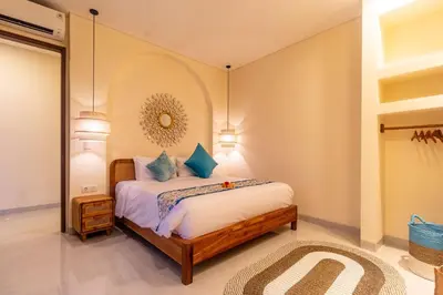 a bedroom with a bed and a mirror at Villa Amaia Bali in Kerobokan