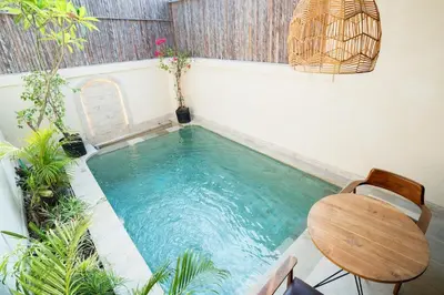 a small swimming pool with a table and a chair at Villa Mentari at Umalas in Kerobokan