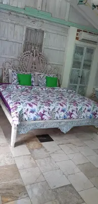 a large bed in a room with green pillows at HI Lonny Villa Seminyak in Seminyak