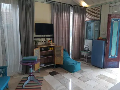 a living room with a tv and a blue couch at HI Lonny Villa Seminyak in Seminyak