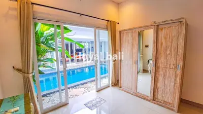 a room with a view of a swimming pool through a door at Villa GOwen in Jimbaran