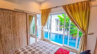 a bedroom with a window with a view of a pool at Villa GOwen in Jimbaran