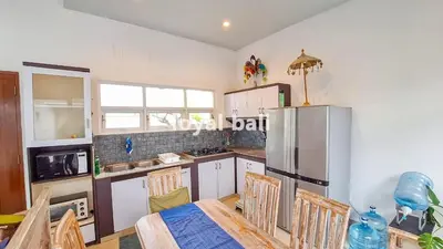 a kitchen with a table with chairs and a refrigerator at Villa GOwen in Jimbaran