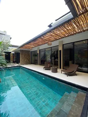 a swimming pool in front of a house at Vila Samatha 2 Nusa Dua in Nusa Dua