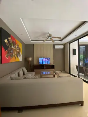 a living room with a couch and a ceiling fan at Vila Samatha 2 Nusa Dua in Nusa Dua