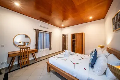 a bedroom with a bed and a mirror and a desk at Villa Kusuma 1 Seminyak in Seminyak