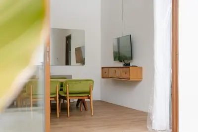 a dining room with a table and a tv on a wall at NEW! Villa Imaera - 2BR Villa in Kerobokan in Kerobokan