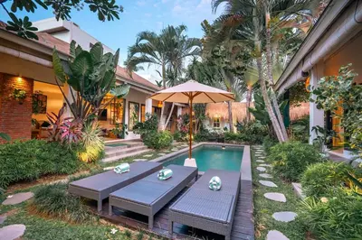 a patio with a table and an umbrella next to a pool at Villa Mint, 3Br Tropical Escape, Near Bintang Supermarket in Seminyak
