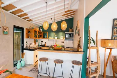 a kitchen with a counter and stools in a room at Villa Mint, 3Br Tropical Escape, Near Bintang Supermarket in Seminyak