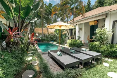 a patio with a table and an umbrella next to a pool at Villa Mint, 3Br Tropical Escape, Near Bintang Supermarket in Seminyak