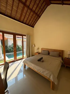 a bedroom with a bed and a large window at Ocean Cantik Villa in Canggu