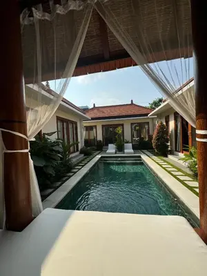 a swimming pool in front of a house at Ocean Cantik Villa in Canggu