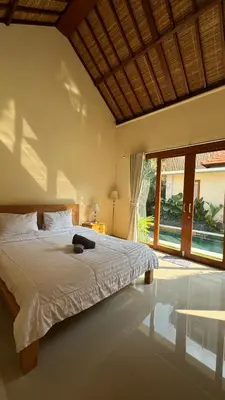 a bedroom with a large bed and a large window at Ocean Cantik Villa in Canggu