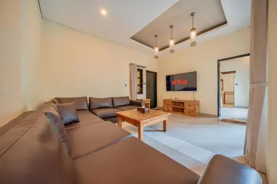 a living room with a couch and a table at Villa Cahaya Berlian in Kerobokan