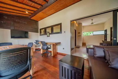 a living room with a television and a table and chairs at Villa Cahaya Berlian in Kerobokan