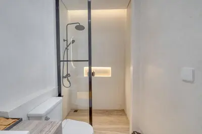 a bathroom with a shower with a toilet and a sink at Villa Isabella 4BR Brand New in Berawa, Canggu in Canggu
