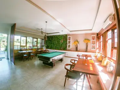 a room with a pool table and some tables at Palm Light Nusa Dua in Nusa Dua