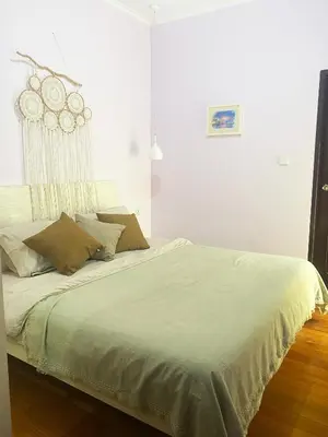 a bedroom with a large bed with white sheets at Palm Light Nusa Dua in Nusa Dua