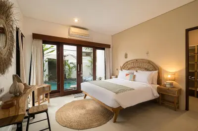 a bedroom with a bed and a large window at Villa Zambrud Sanur Elegant Tropical Villa with Private Pool & Garden and Garage in Sanur