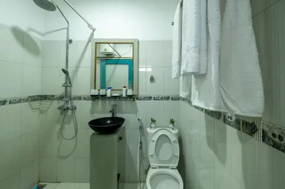 a white bathroom with a toilet and a sink at Beachview Residence in Seminyak
