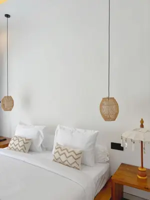 a white bed with white pillows and a table at Brand New Serene Balinese Villa with Private Pool in Kerobokan