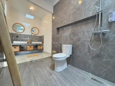 a bathroom with a toilet and a shower and a sink at Brand New Serene Balinese Villa with Private Pool in Kerobokan