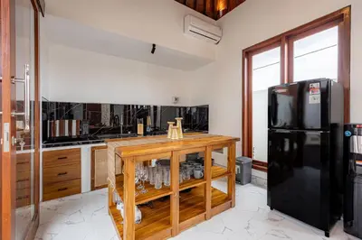 a kitchen with a black refrigerator and a counter at Brand New Serene Balinese Villa with Private Pool in Kerobokan