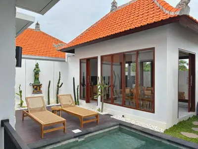 a villa with a swimming pool and a house at Brand New Serene Balinese Villa with Private Pool in Kerobokan