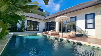 a swimming pool in front of a house at Villa Sofia in Seminyak
