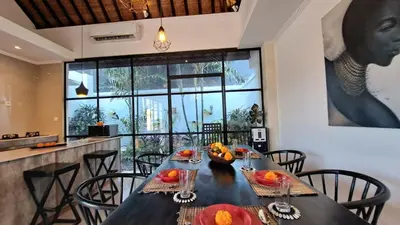 a dining room with a black table and chairs at Villa Sofia in Seminyak