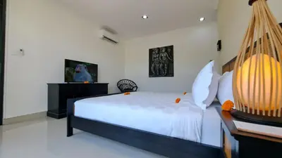 a bedroom with a large bed with white walls at Villa Sofia in Seminyak