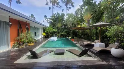 a swimming pool with chairs and an umbrella at Seminyak Tropical Oasis Center-3 Br-Private Pool in Seminyak