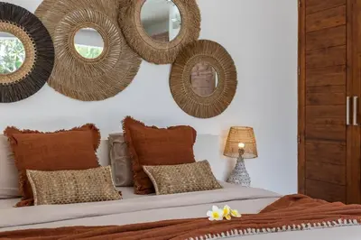 a bedroom with a bed with pillows and mirrors on the wall at Seminyak Tropical Oasis Center-3 Br-Private Pool in Seminyak