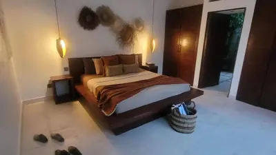 a bedroom with a bed and some shoes on the floor at Seminyak Tropical Oasis Center-3 Br-Private Pool in Seminyak