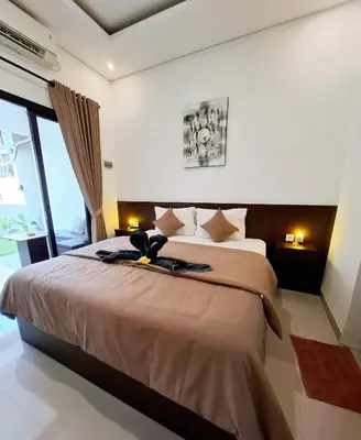 a bedroom with a large bed and a large window at Wisman House by Pigeon in Jimbaran
