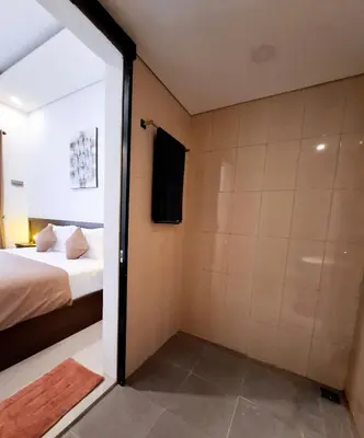 a bedroom with a bed and a shower in a room at Wisman House by Pigeon in Jimbaran