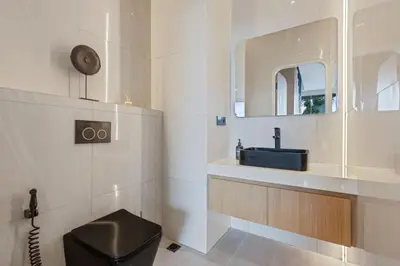 a bathroom with a black toilet and a sink at New 2BR Architectural Masterpiece in Umalas in Kerobokan