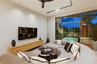 a living room with a couch and a tv at New 2BR Architectural Masterpiece in Umalas in Kerobokan